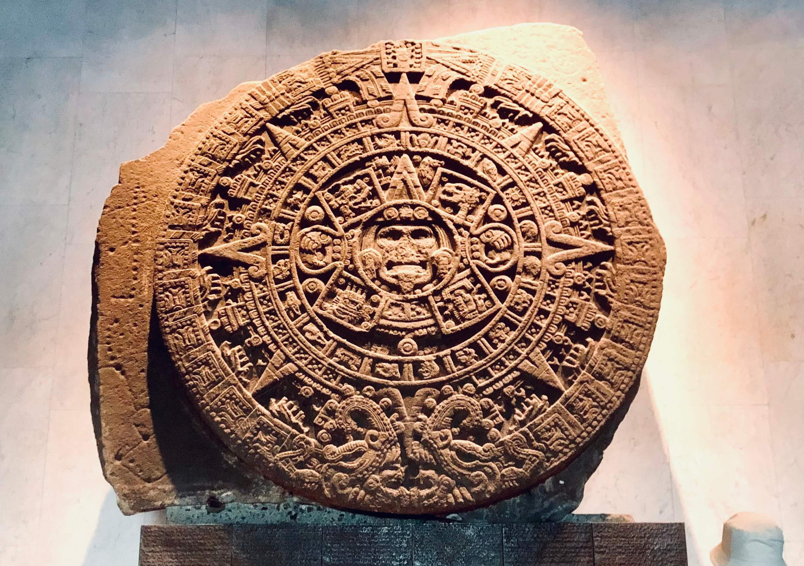 The Aztec Sun Stone: A Masterpiece of History Close-up detail of the ancient Aztec Sun Stone (Piedra del Sol) exhibited in a museum, highlighting the rich cultural heritage featured in our curated Mexico City tours.