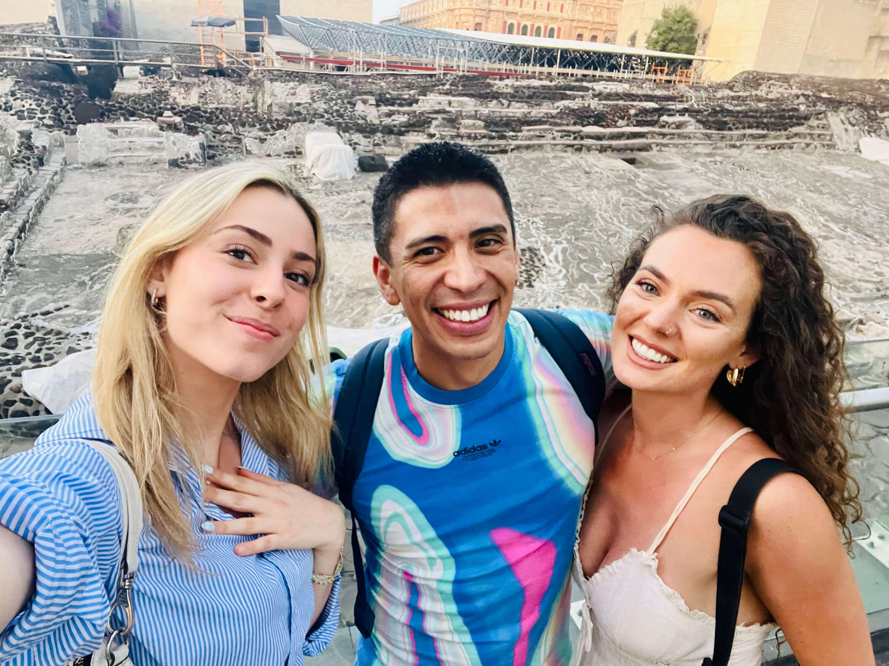 Unforgettable Guest Moments at Templo Mayor A joyful group selfie of Erik and two smiling guests at the ancient Templo Mayor ruins in Mexico City